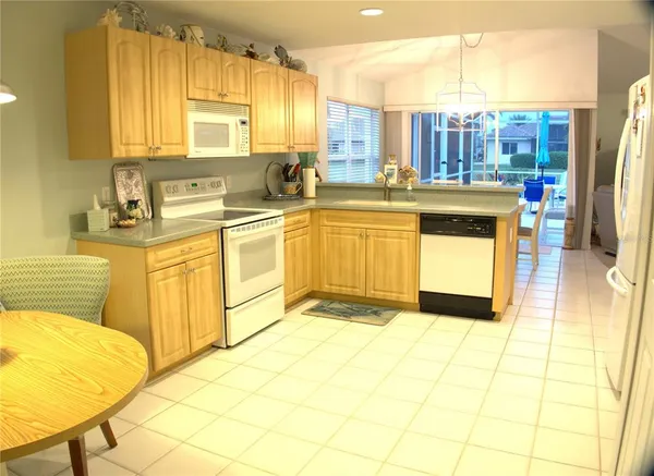 a view of a kitchen with refrigerator and wooden floor
