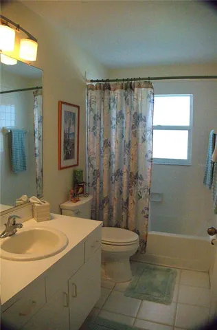 a view of a patio with couches table and chairs under an umbrella