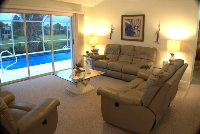 a living room with furniture a lamp and a floor to ceiling window