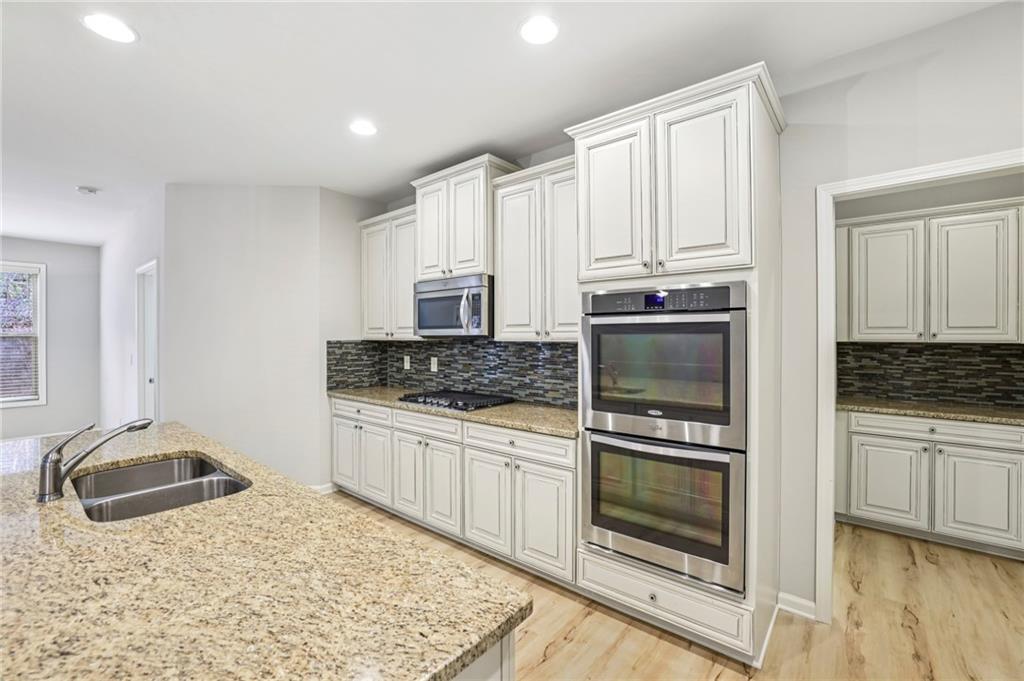 1210 Roswell Manor Circle Roswell, GA 30076 - Photo 12 of 43 a kitchen with granite countertop a stove sink and cabinets