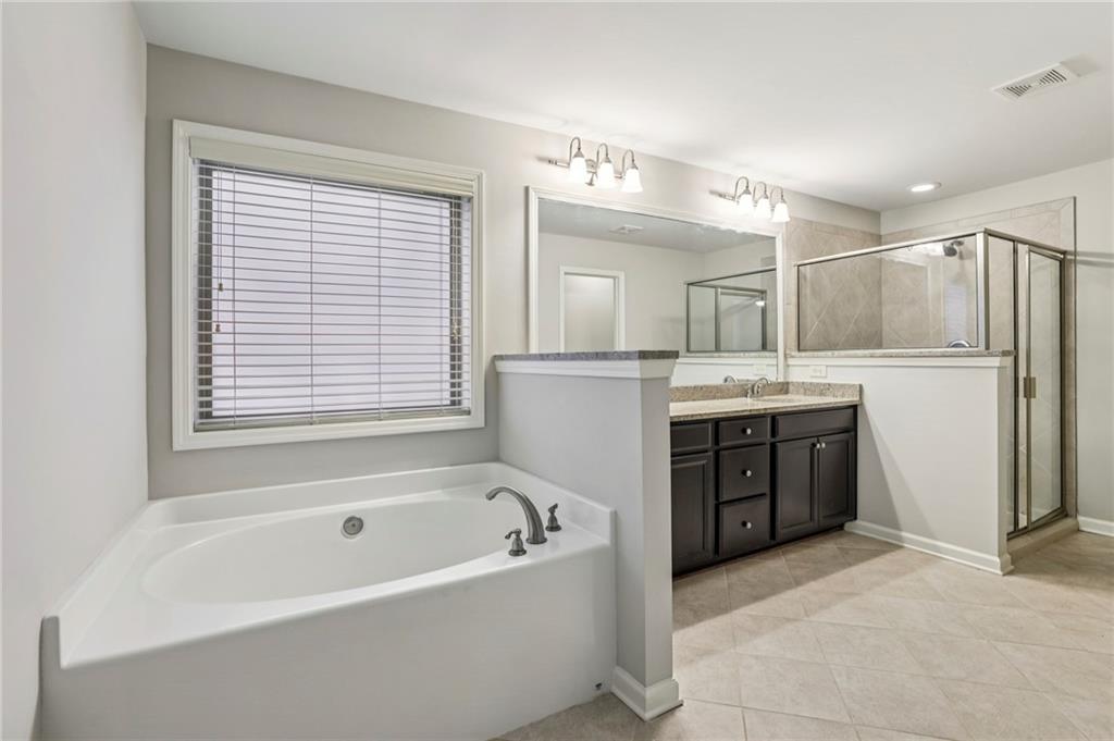 1210 Roswell Manor Circle Roswell, GA 30076 - Photo 25 of 43 a spacious bathroom with a tub sink and mirror