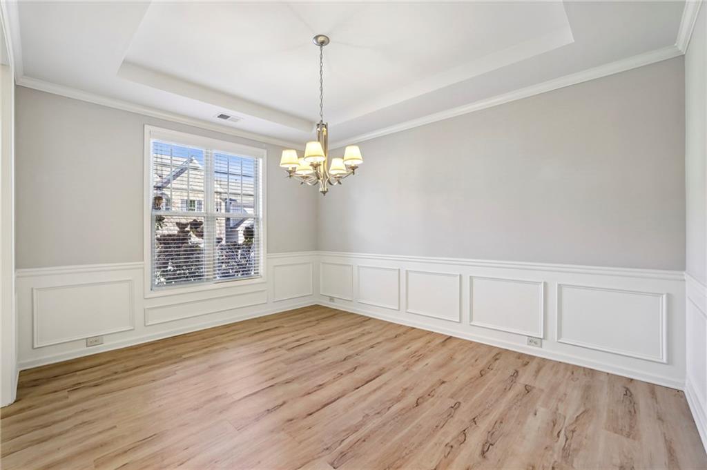 1210 Roswell Manor Circle Roswell, GA 30076 - Photo 5 of 43 a view of an empty room with wooden floor and a window