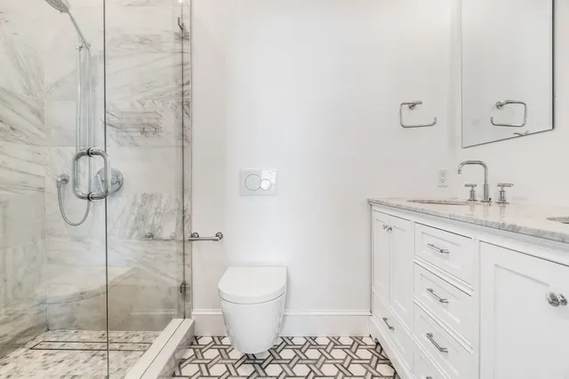 a bathroom with a sink a toilet and shower