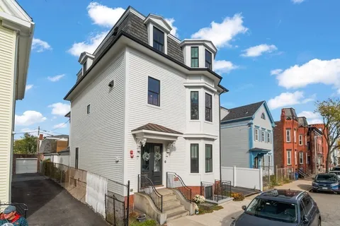 a view of a white building among the street with palm trees
