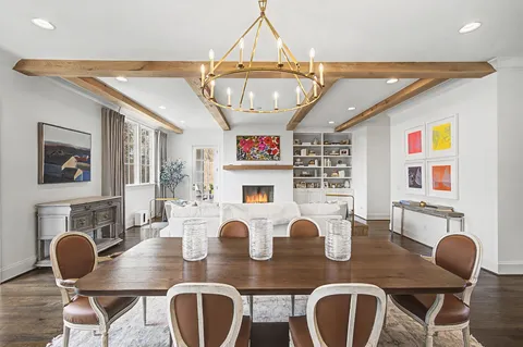 a living room with furniture a chandelier and a floor to ceiling window