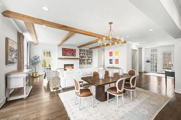 a living room with furniture a chandelier and a floor to ceiling window