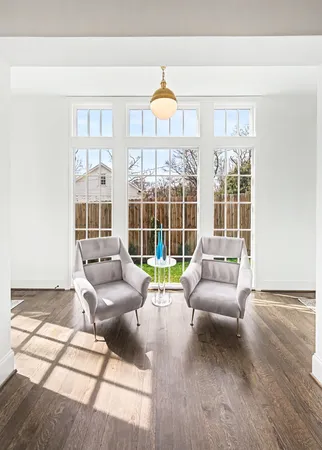a large white kitchen with lots of counter space a sink appliances and living room view