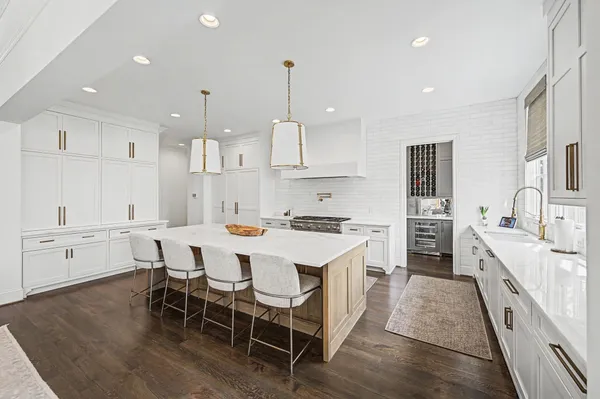 a kitchen with stainless steel appliances granite countertop a kitchen island a stove a table and chairs