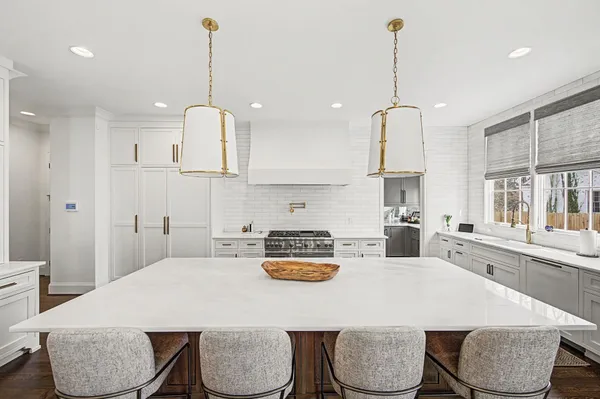 a kitchen with a sink a stove a refrigerator and white cabinets