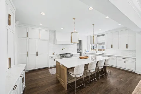 a large kitchen with stainless steel appliances lots of counter space and windows