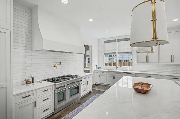 a large kitchen with stainless steel appliances lots of counter space and windows