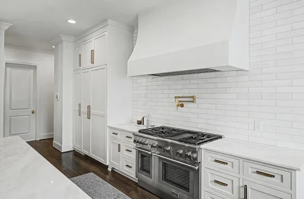 a kitchen with stainless steel appliances a refrigerator and a wooden floor