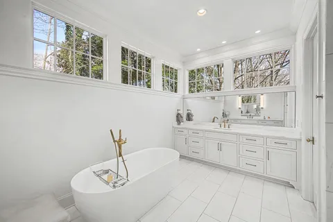 a living room with furniture floor to ceiling window hardwood floor and a flat screen tv
