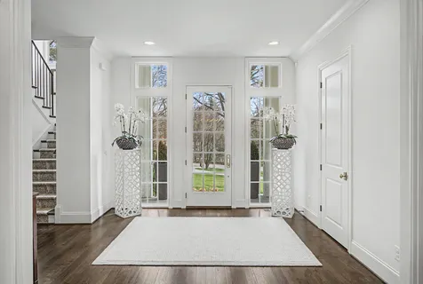 a view of a hallway with wooden floor and a bathroom
