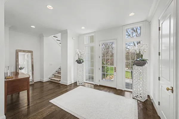 a view of a hallway with wooden floor and a bathroom