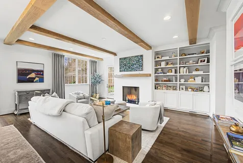 a living room with furniture kitchen view and a large window