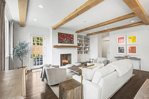 a living room with furniture kitchen view and a large window