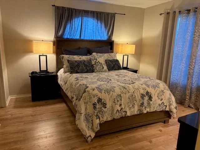 a large bed sitting in a bedroom next to a lamp