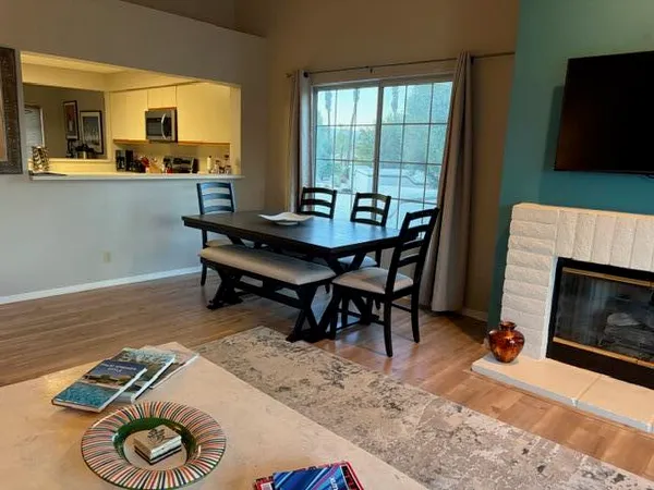 a view of a hallway with wooden floor and a flat screen tv