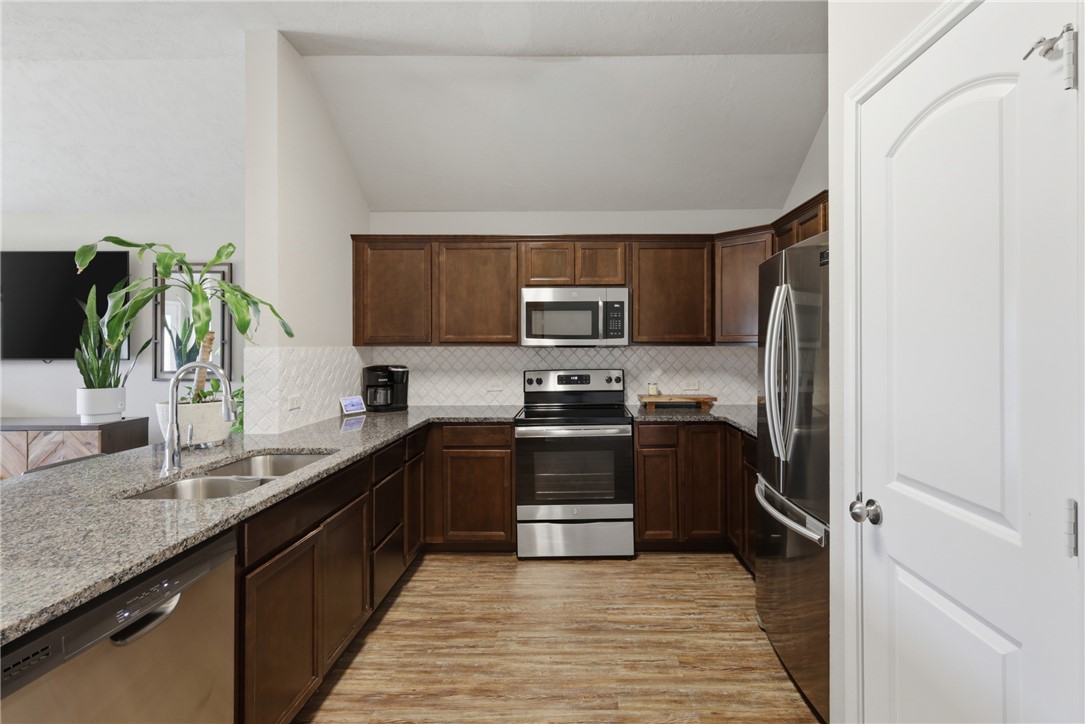 2725 Porter's Way Bryan, TX 77803 - Photo 6 of 19 a kitchen with stainless steel appliances granite countertop a refrigerator and a sink