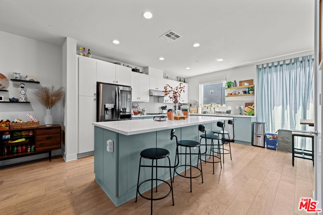 4326 Eagle Rock Boulevard Los Angeles, CA 90041 - Photo 10 of 33 a kitchen with stainless steel appliances kitchen island granite countertop a refrigerator a stove a sink a dining table and chairs with wooden floor
