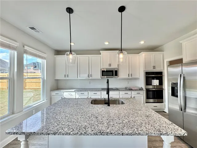 a kitchen with kitchen island granite countertop a counter top space appliances and cabinets