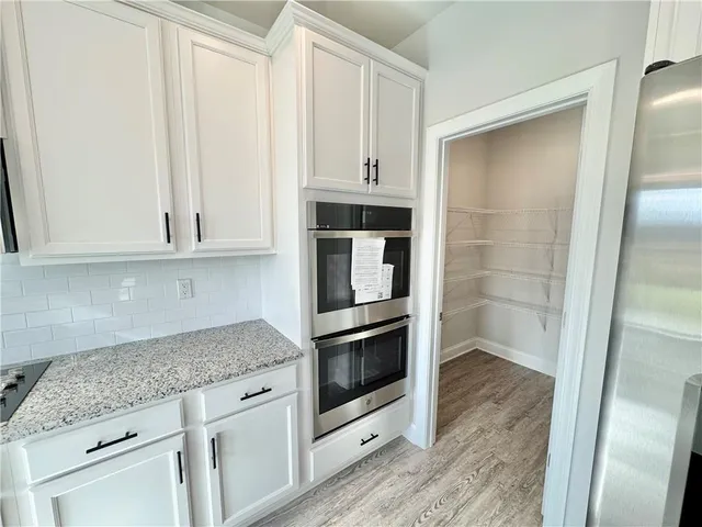 a kitchen with granite countertop white cabinets and stainless steel appliances