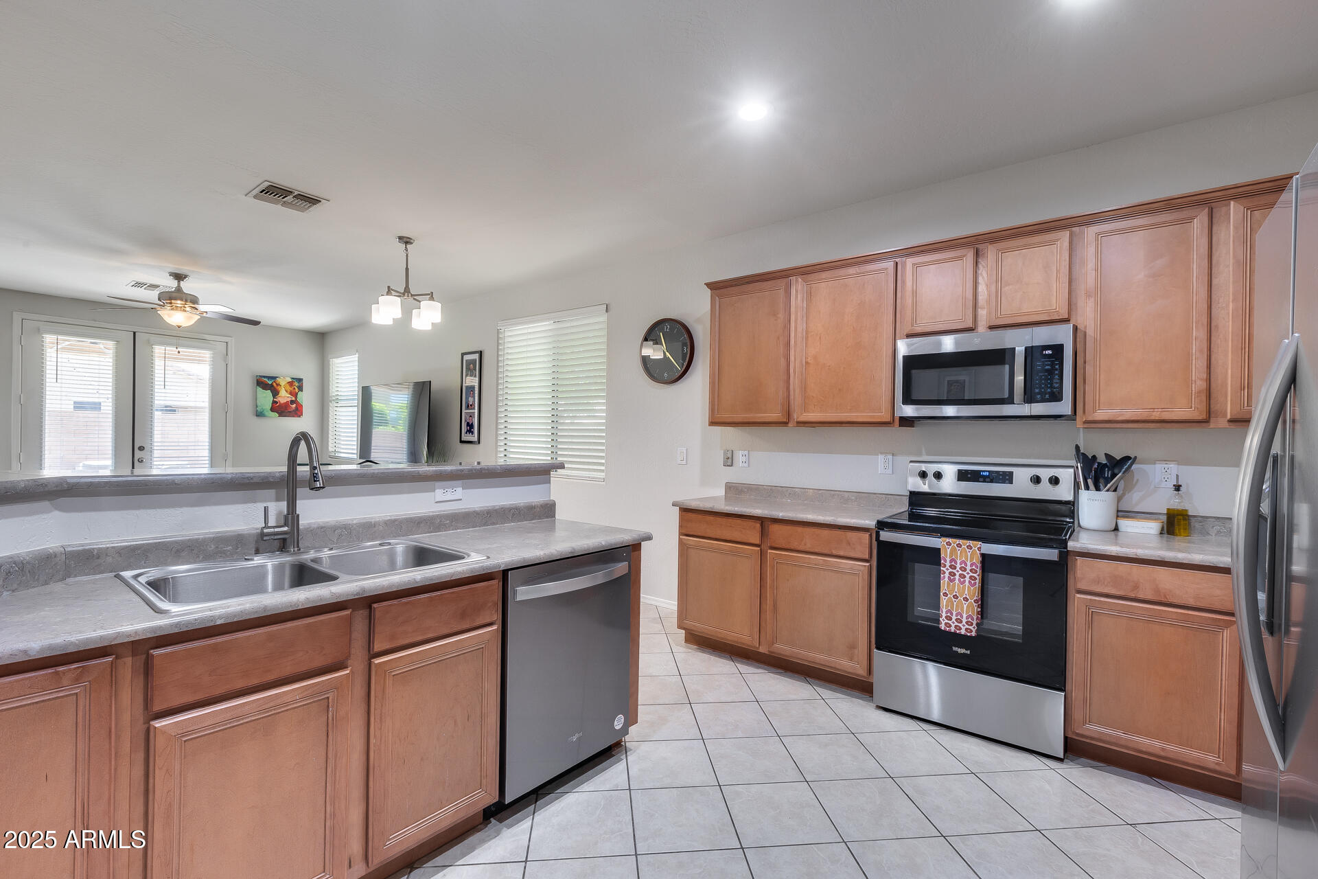 14229 West Calavar Road Surprise, AZ 85379 - Photo 3 of 44 a kitchen with stainless steel appliances granite countertop a stove top oven a sink and dishwasher