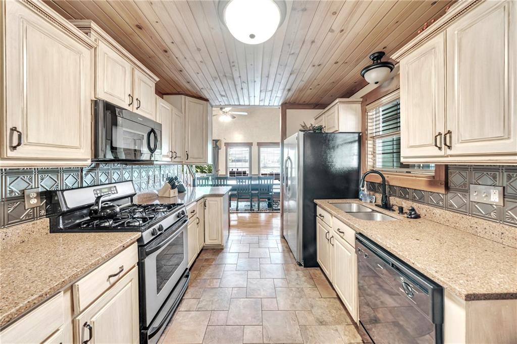 2003 Bend Of The River Road Hiawassee, GA 30546 - Photo 25 of 80 a kitchen with stainless steel appliances granite countertop a sink a stove and a wooden floors