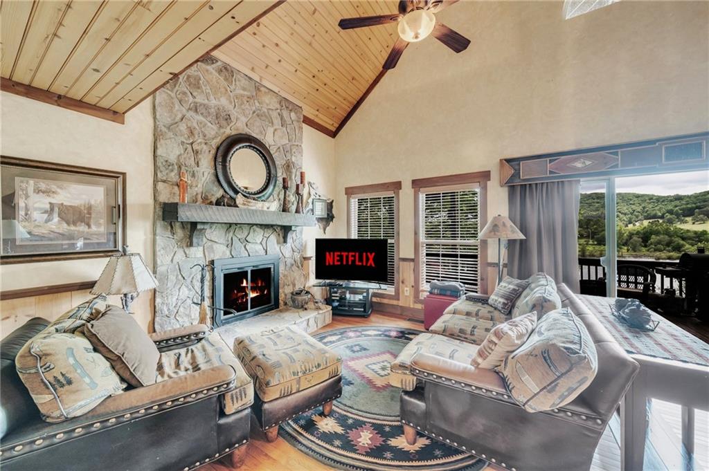 2003 Bend Of The River Road Hiawassee, GA 30546 - Photo 26 of 80 a living room with furniture a fireplace and a floor to ceiling window