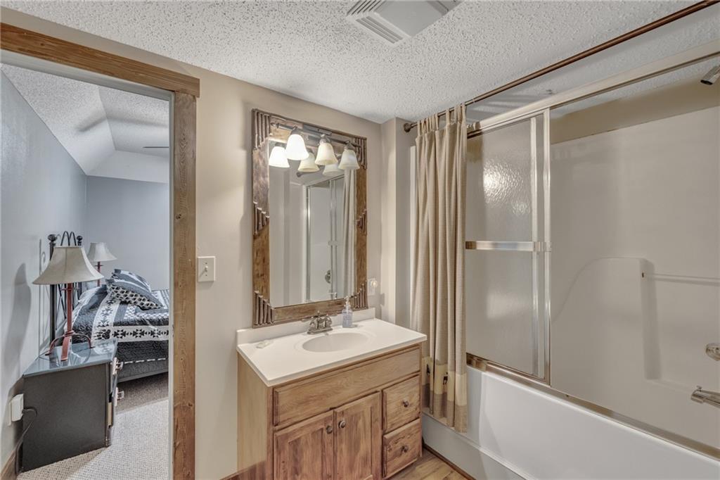 2003 Bend Of The River Road Hiawassee, GA 30546 - Photo 35 of 80 a bathroom with a shower sink vanity and mirror