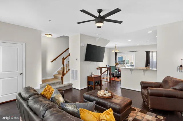 a living room with furniture kitchen view and a flat screen tv