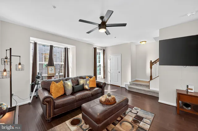 a living room with furniture and a flat screen tv with wooden floor