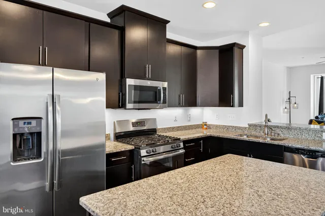 a kitchen with a sink stainless steel appliances and refrigerator