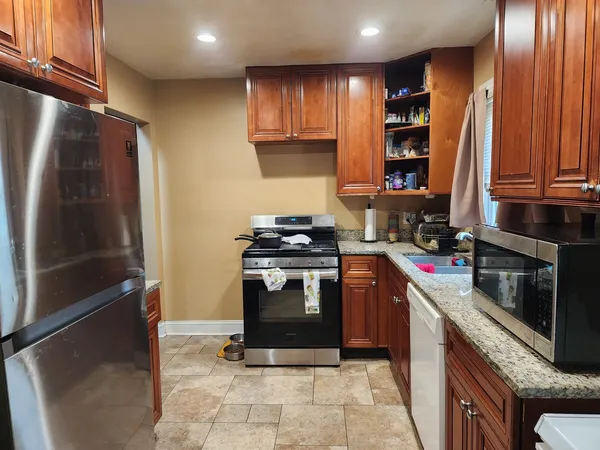 a kitchen with stainless steel appliances granite countertop a stove a refrigerator and a sink
