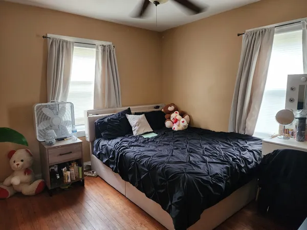 a bedroom with a bed and wooden floor