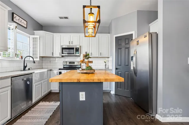 a kitchen with stainless steel appliances granite countertop a sink stove and microwave