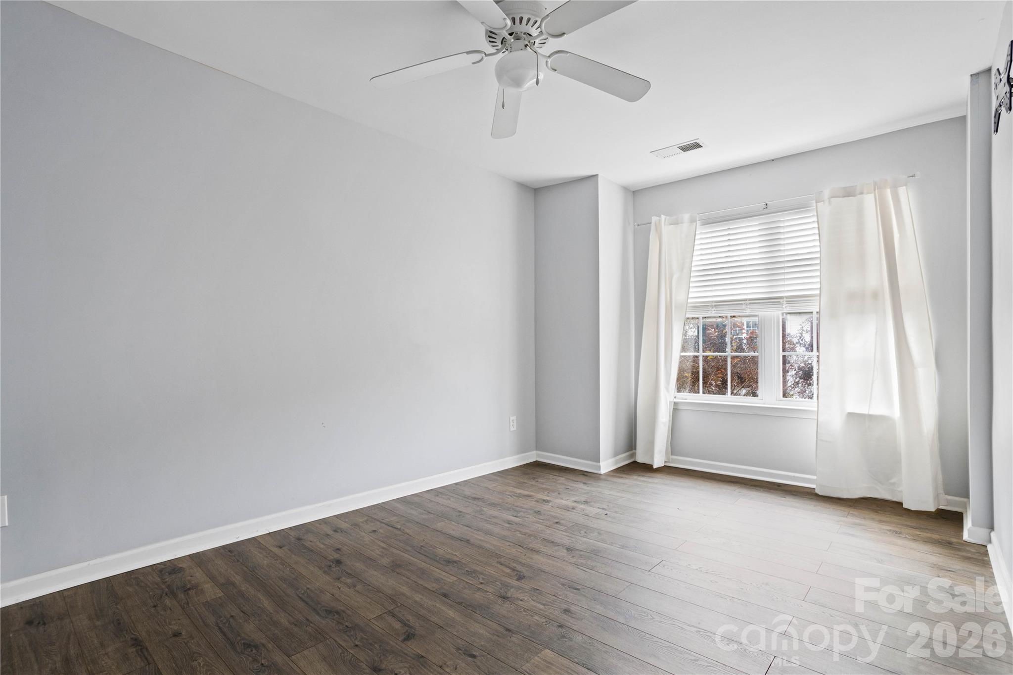 101 Rock Ridge Lane Mount Holly, NC 28120 - Photo 15 of 35 an empty room with wooden floor fan and windows