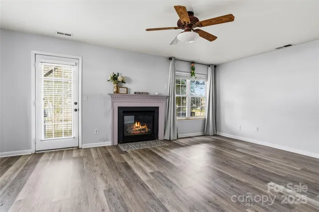 a view of an empty room with a fireplace and a window