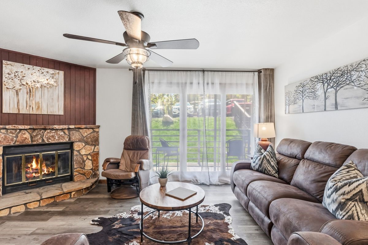 89410 Ryan Gulch Road, Unit 208 Silverthorne, CO 80498 - Photo 12 of 30 a living room with furniture a fireplace and a large window