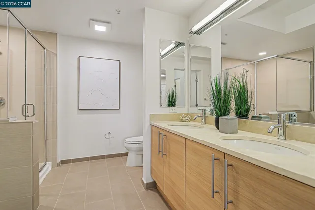 a bathroom with a double vanity sink a mirror and a toilet