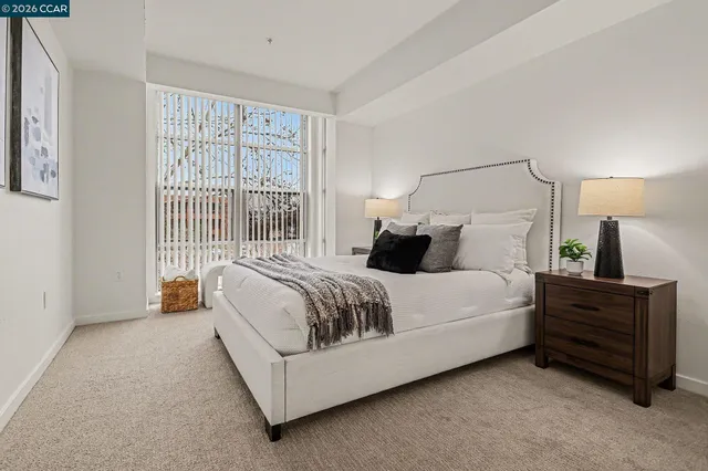 a bedroom with a bed lamp and a large window