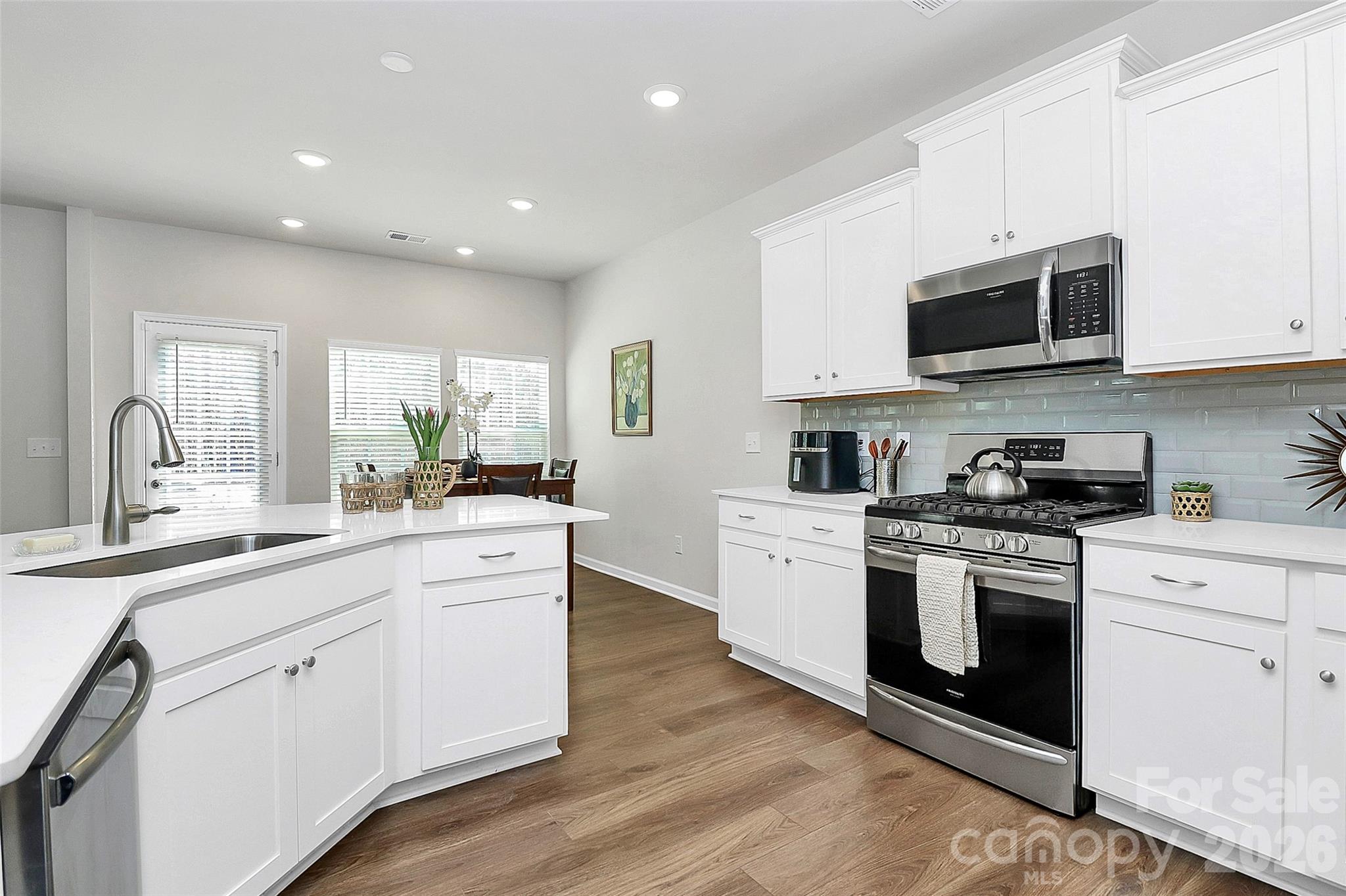 5766 Soft Shell Drive Lancaster, SC 29720 - Photo 12 of 33 a kitchen with stainless steel appliances granite countertop grey cabinets a sink a stove a microwave and wooden floors