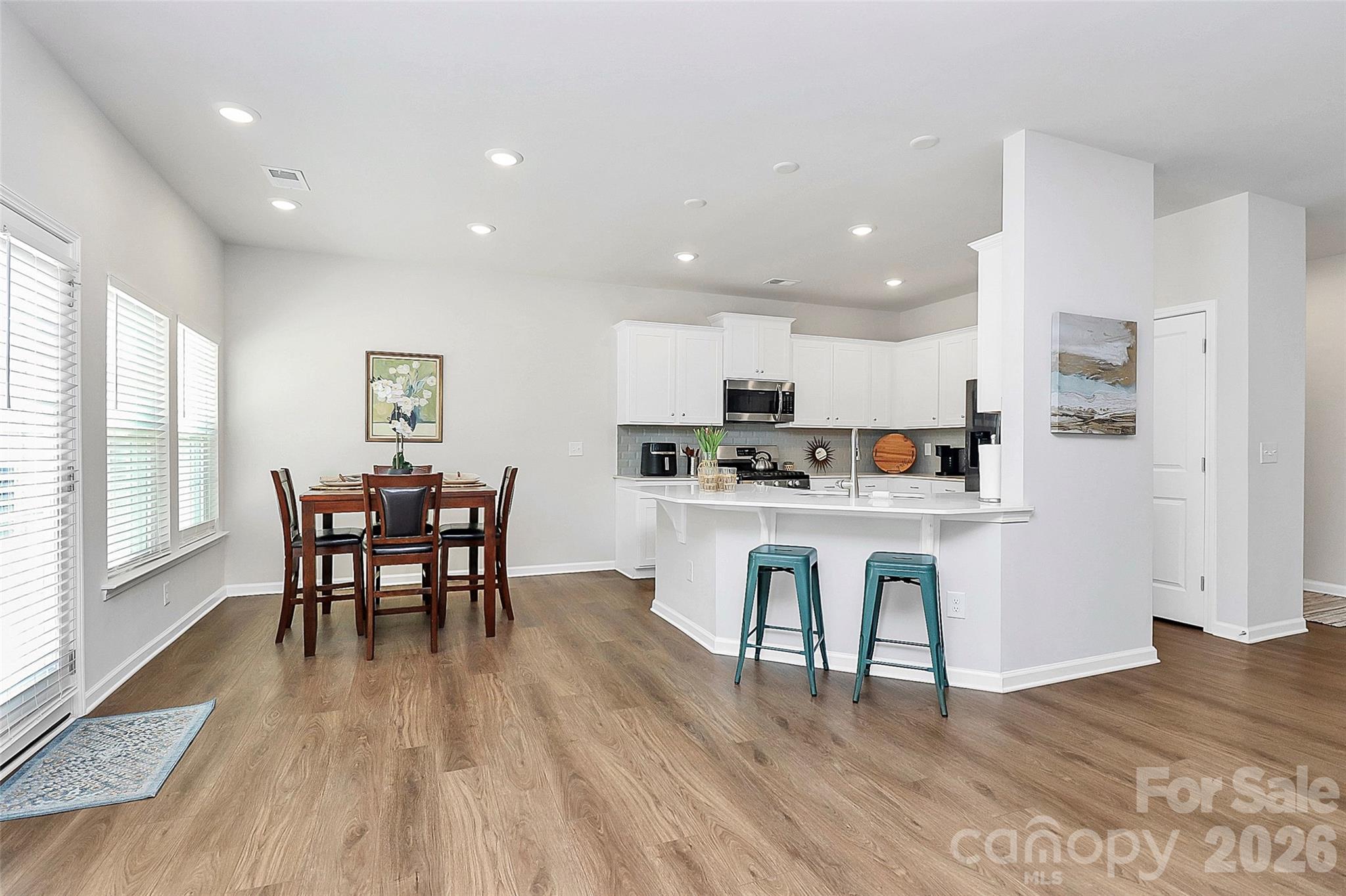 5766 Soft Shell Drive Lancaster, SC 29720 - Photo 8 of 33 a kitchen with white cabinets stainless steel appliances with chair and table