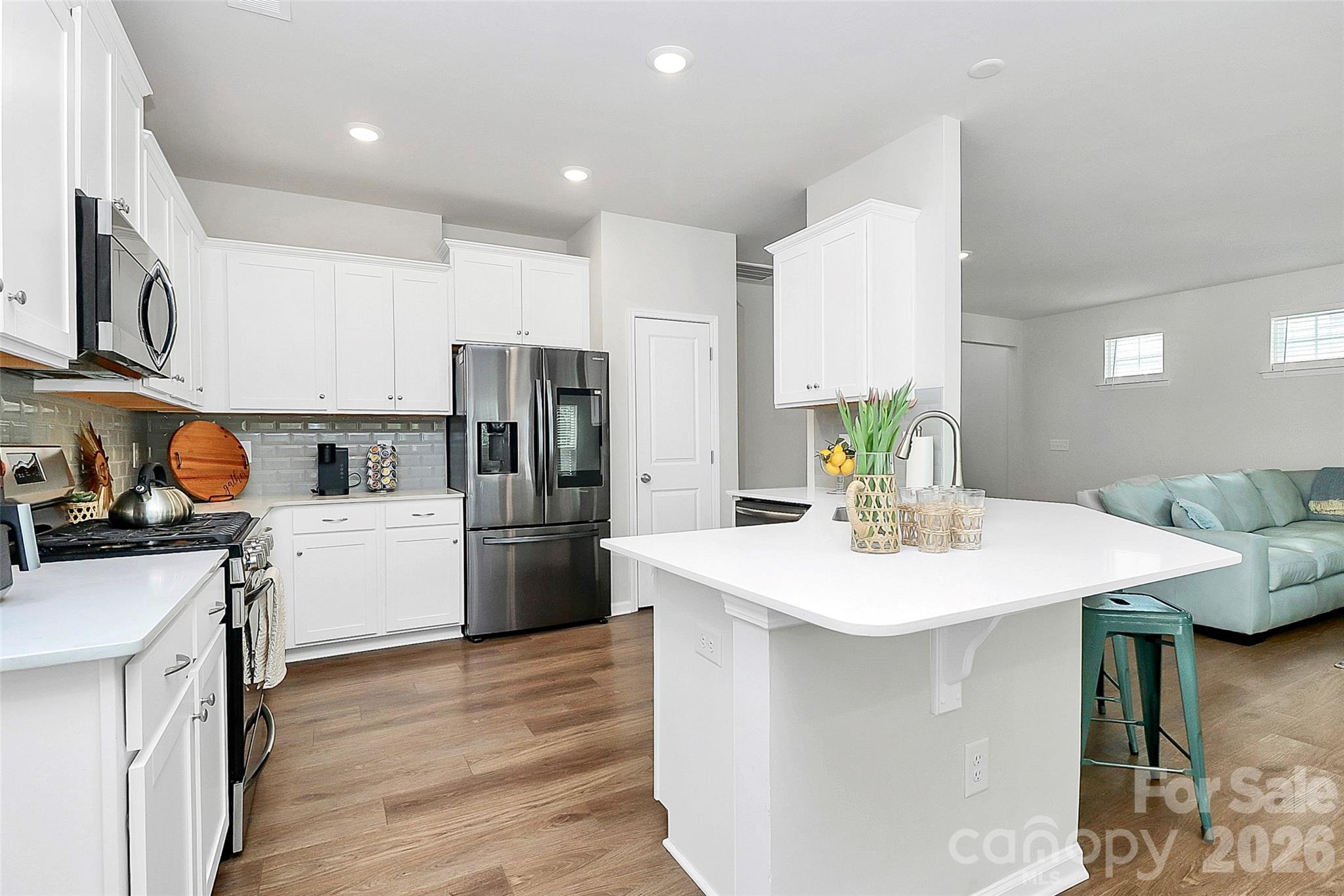 5766 Soft Shell Drive Lancaster, SC 29720 - Photo 10 of 33 a kitchen with a sink a stove a refrigerator and white cabinets with wooden floor