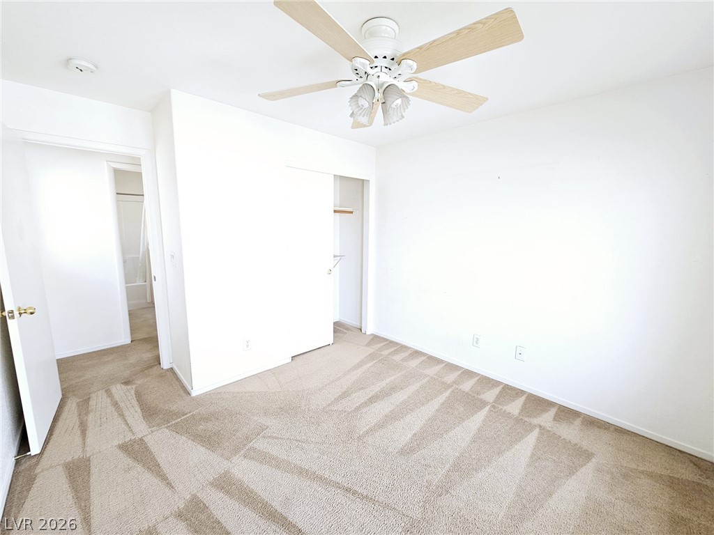1663 Lefty Garcia Way Henderson, NV 89002 - Photo 11 of 31 A comfortable bedroom features plush carpeting and a ceiling fan for optimal comfort.