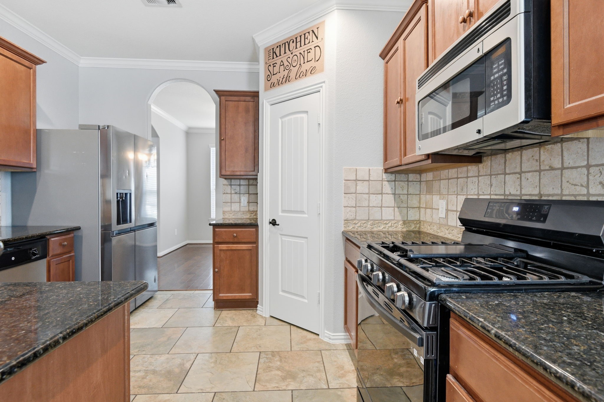 7 Maple Mill Court Conroe, TX 77301 - Photo 8 of 21 a kitchen with stainless steel appliances granite countertop a stove and a refrigerator