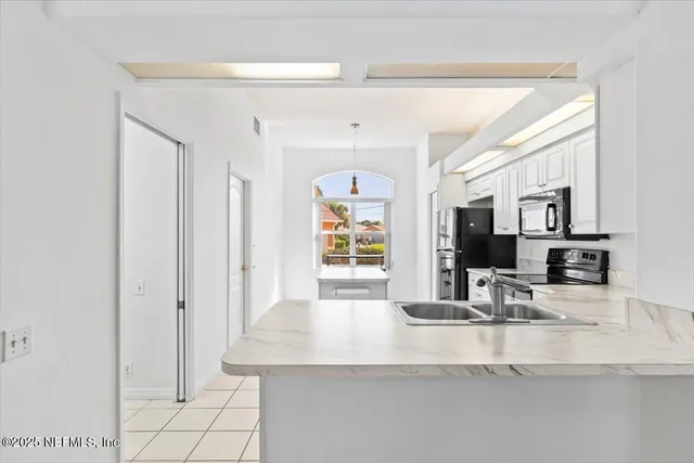 a kitchen with stainless steel appliances a sink and a mirror