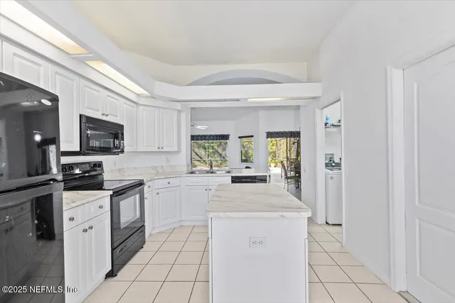 a kitchen with white cabinets and appliances