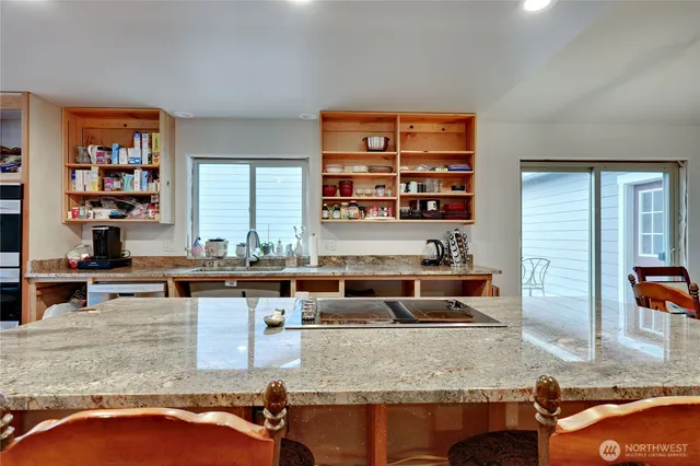 a view of living room kitchen with stainless steel appliances granite countertop cabinets and a couch